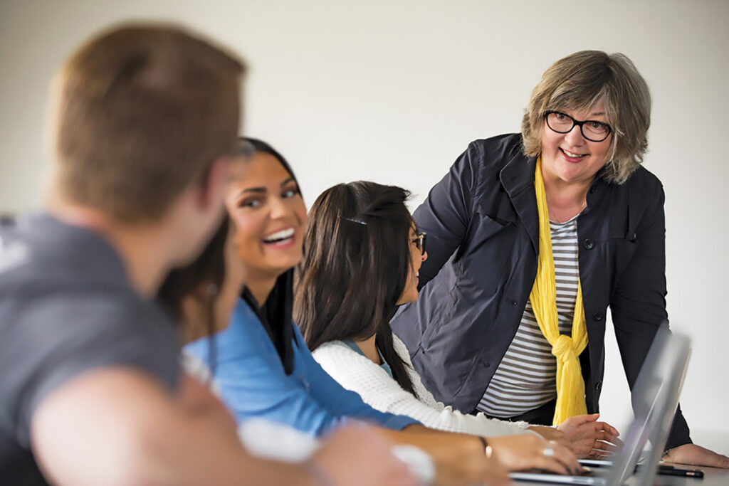 Students in class chatting with professor