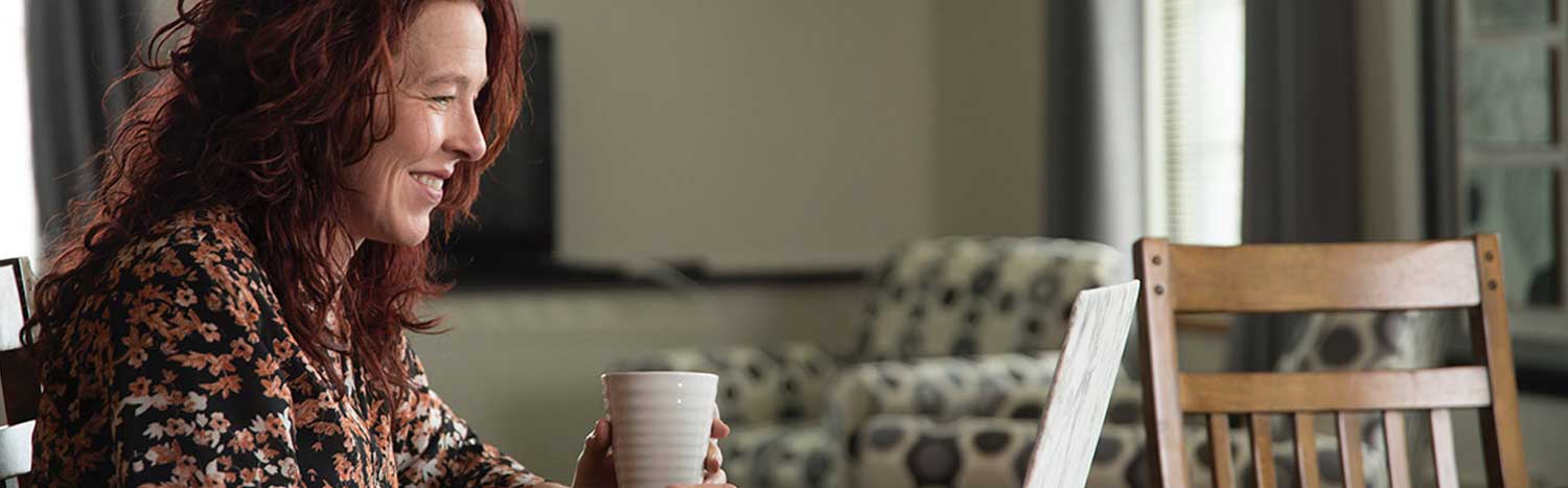 Adult Woman Sitting At Table With Laptop