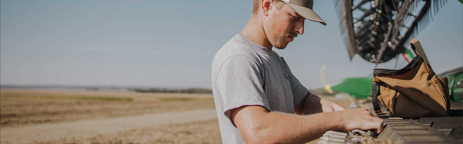 Ag Student Fixing Bean Head On Combine