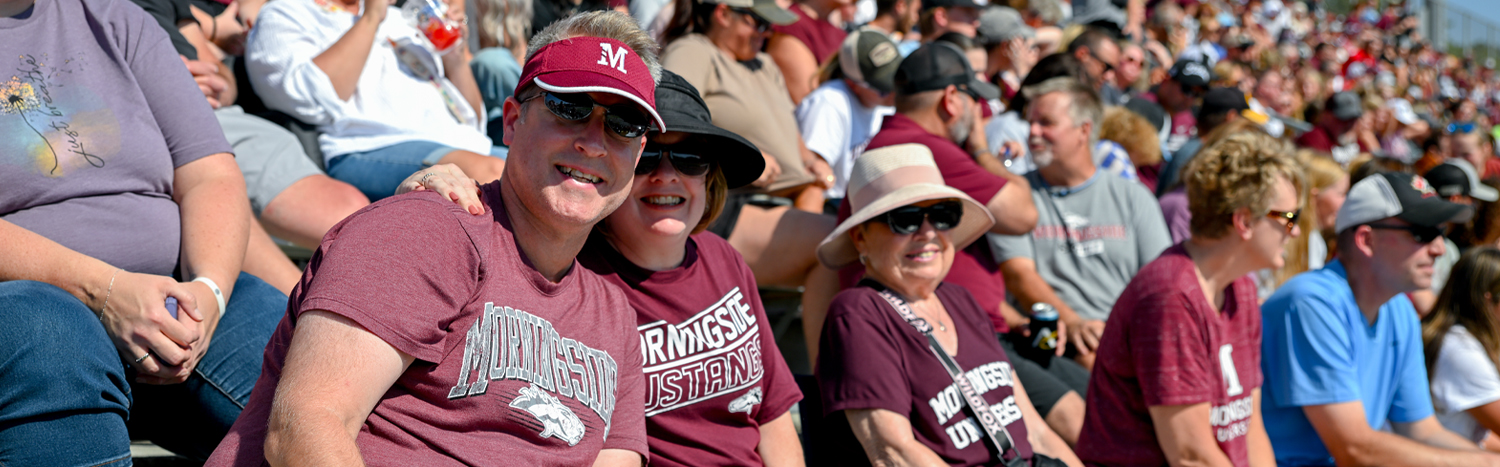 A group of people sitting in the crowd at a football stadium