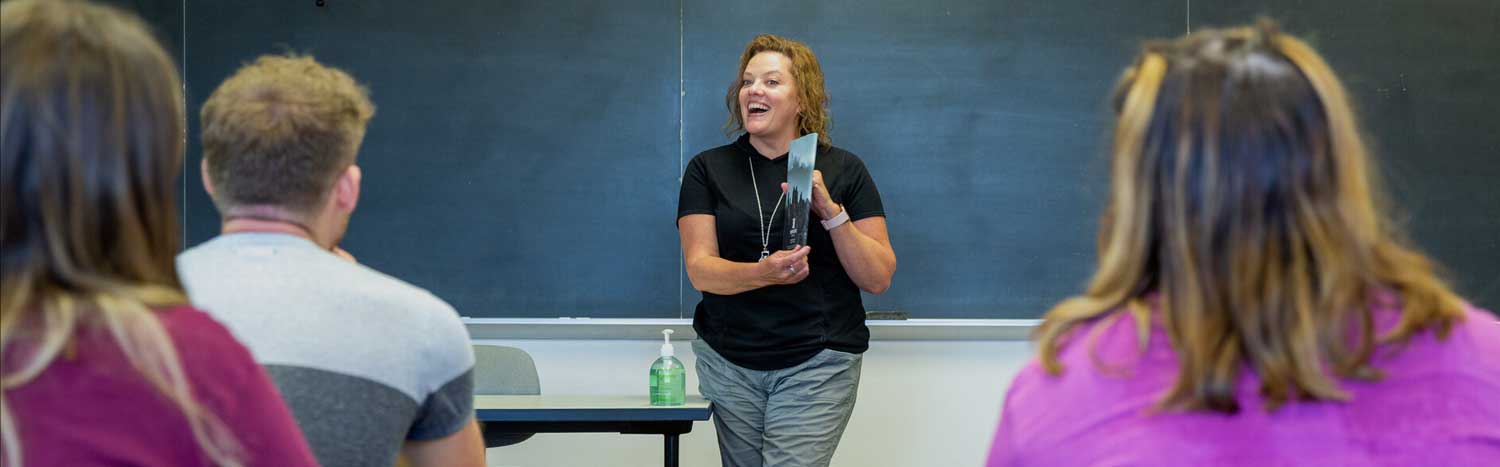 English Professor Holding Book In Class