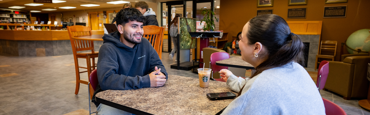Two students sitting at a table in the library