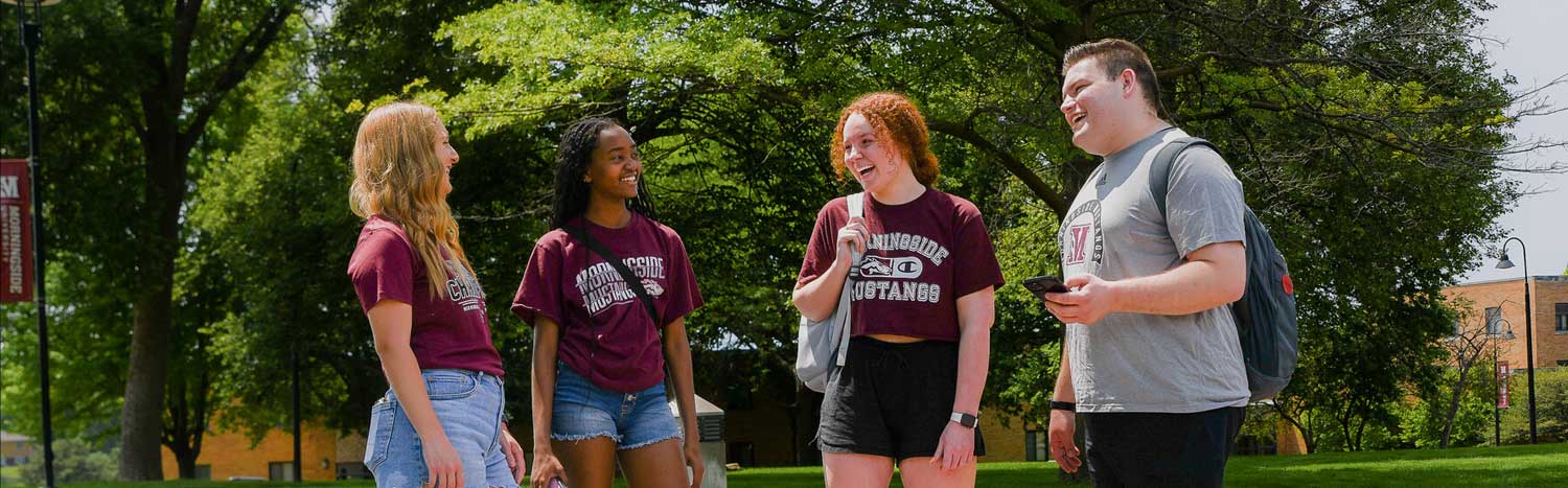 Four Students Laughing On Campus