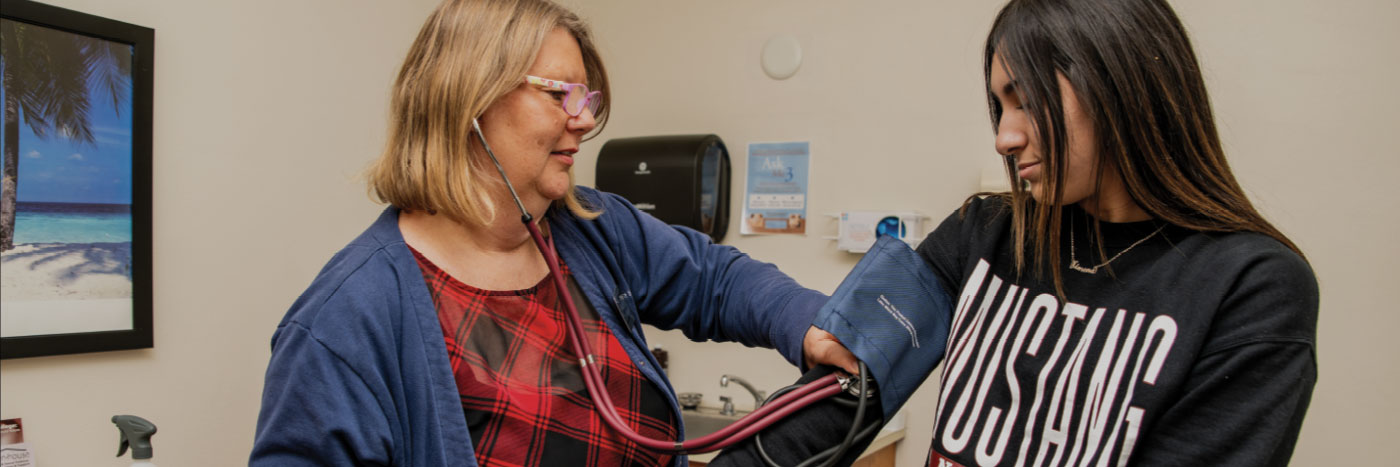 student getting blood pressure checked by campus nurse