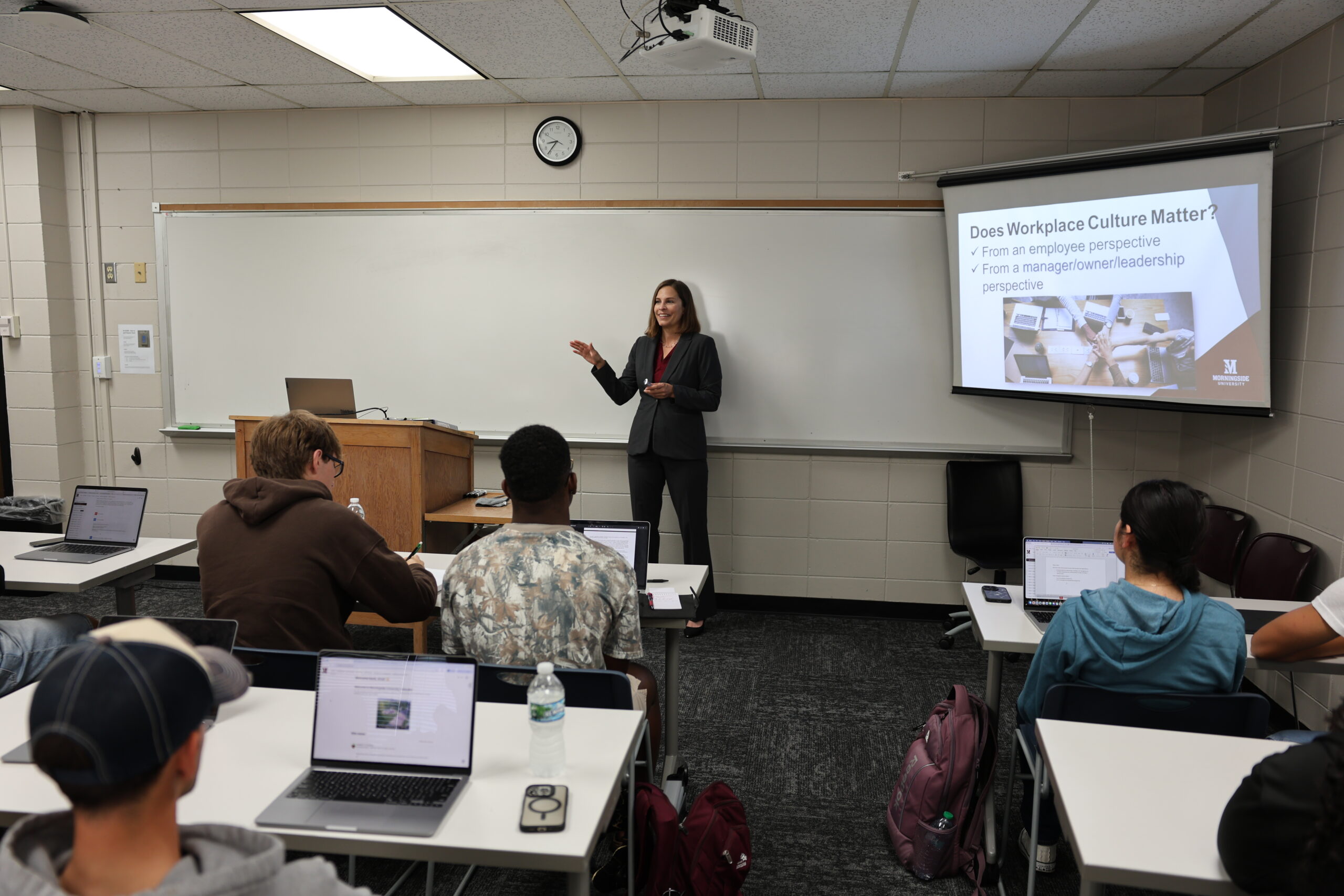 Professor lecturing to students in a classroom.