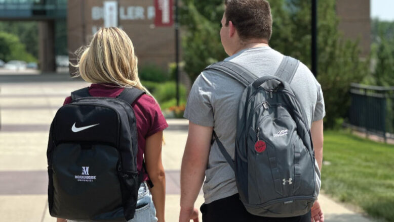 two students walking with backpacks