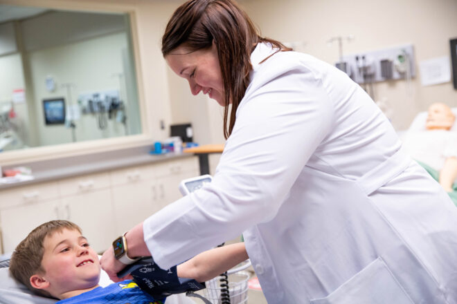 Nurse taking blood pressure on boy