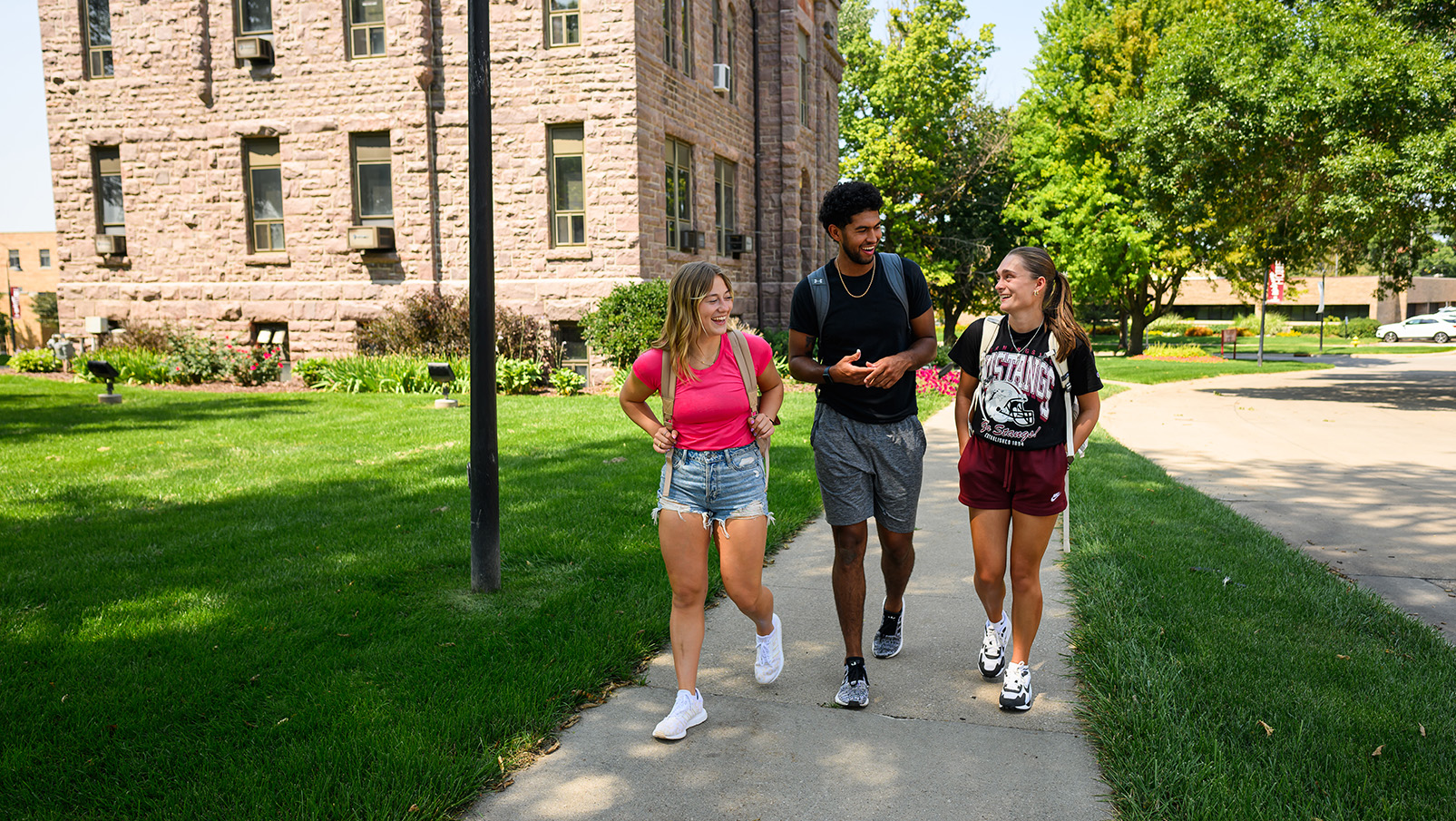 One Male And Two Female Students Walking On Morningside University Campus