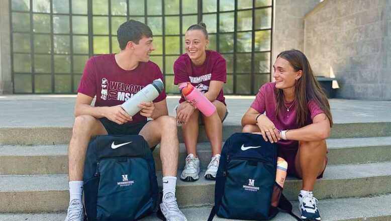 three students sitting on steps with Nike backpacks and Owalas