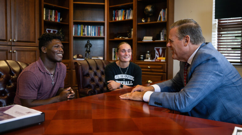 President Benson meeting with two students in his office