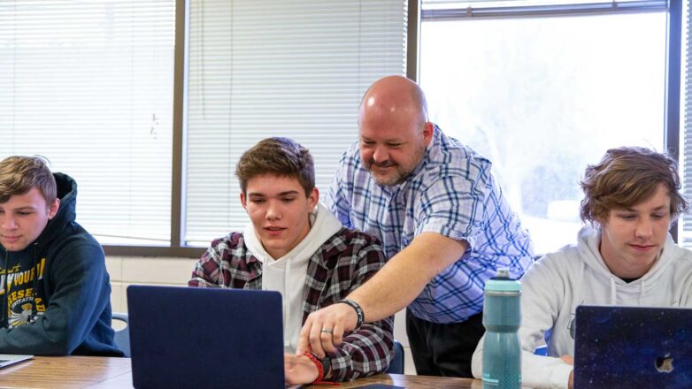 Professor Helping Student In Class