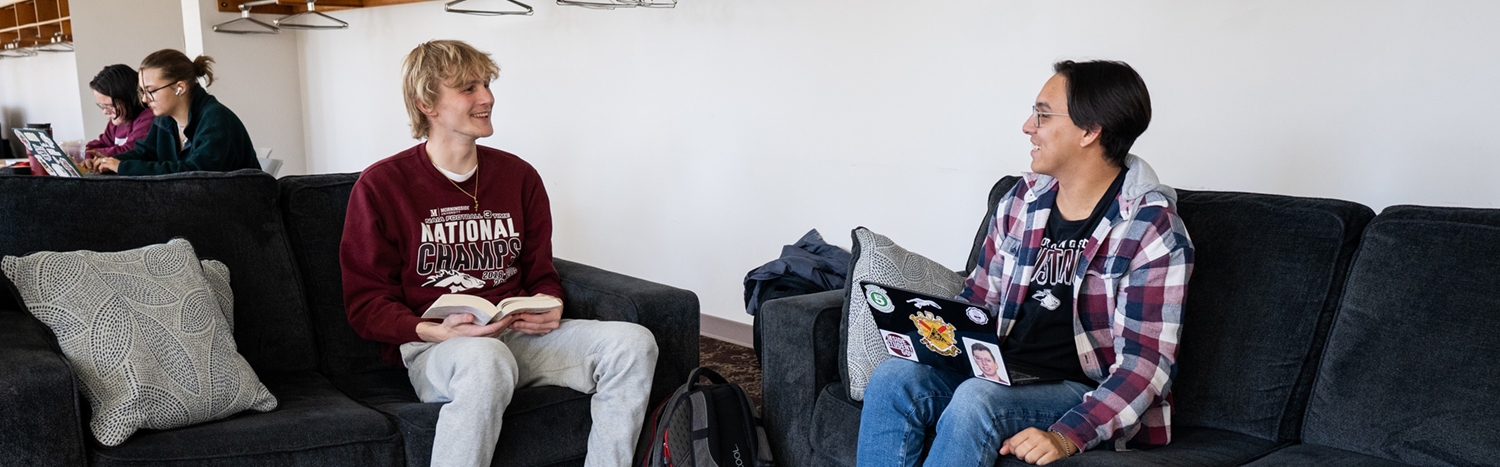 Two students talking in a lounge area