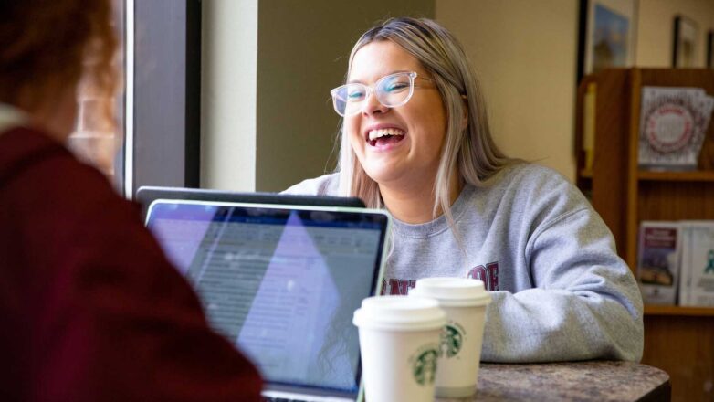 Student Sitting In Library Laughing