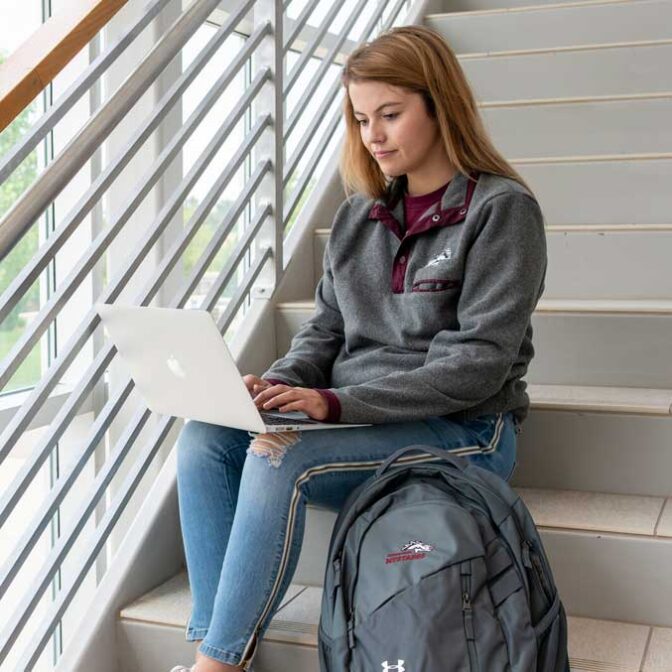Student Sitting On Stairs With Laptop