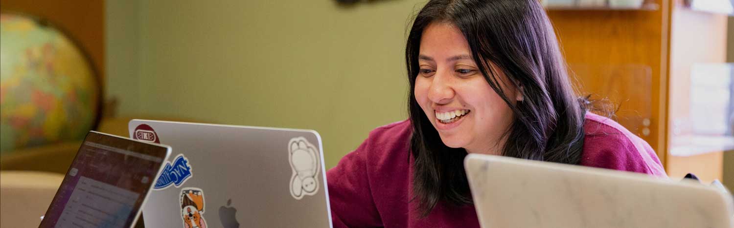 Student Studying In Library With Laptop