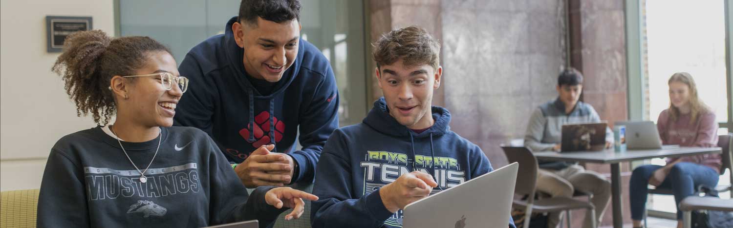 Three Students Pointing At Laptop