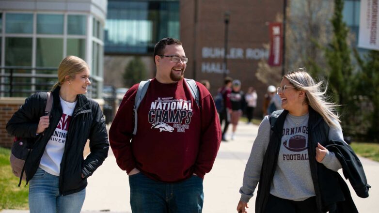 Three Students Walking Through Campus