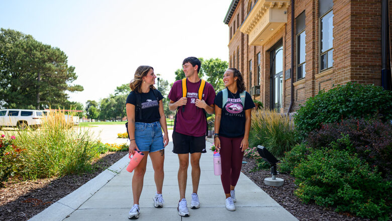 Two female and one male student walking by Lewis Hall