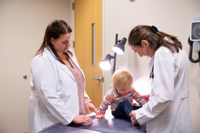 Two graduate nursing students with toddler