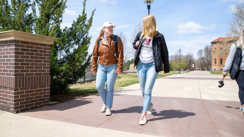 Two Students Walking By Library