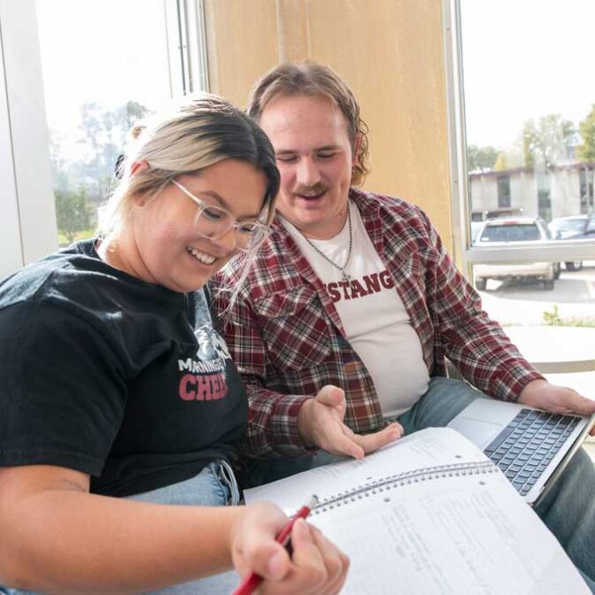 Two Students With Notebook And Laptop