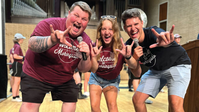 three students cheering on stage