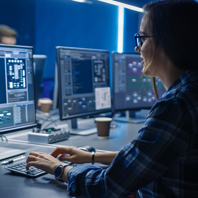 Woman sitting at computer looking at html code