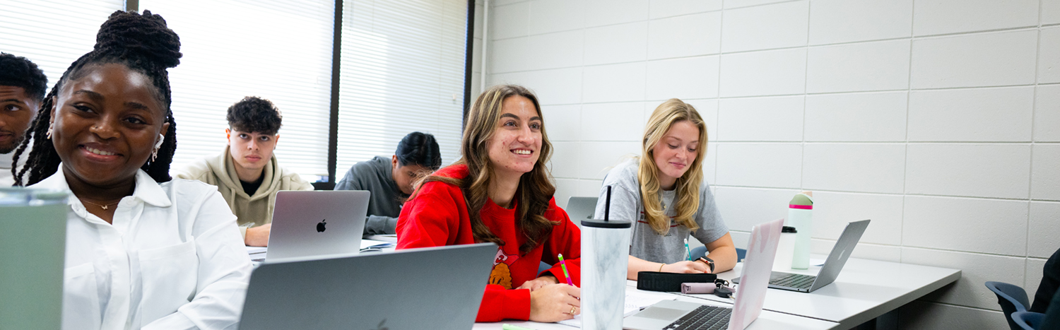 Students sitting at a row of desks in a classroom
