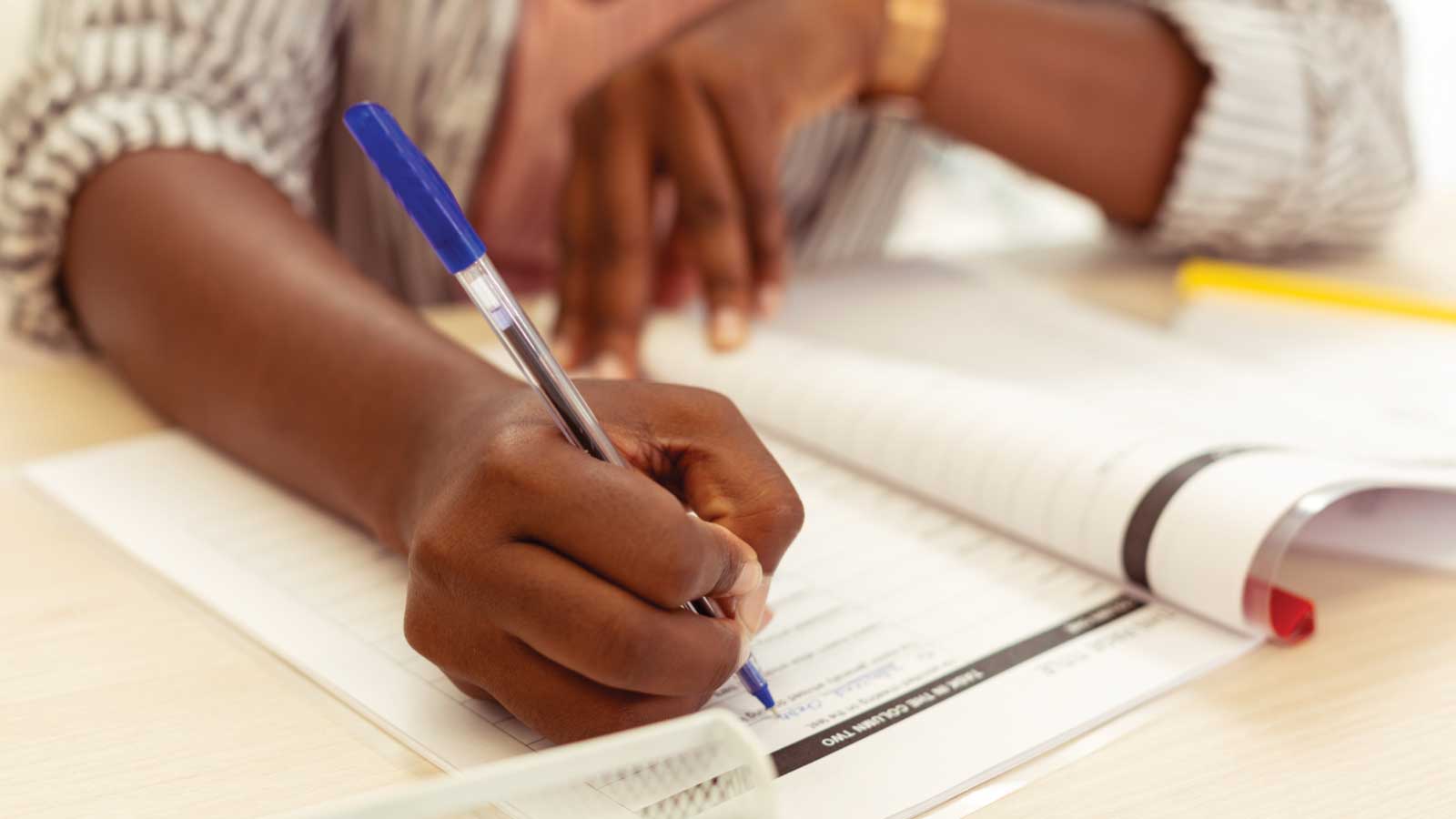 close up of person writing in book