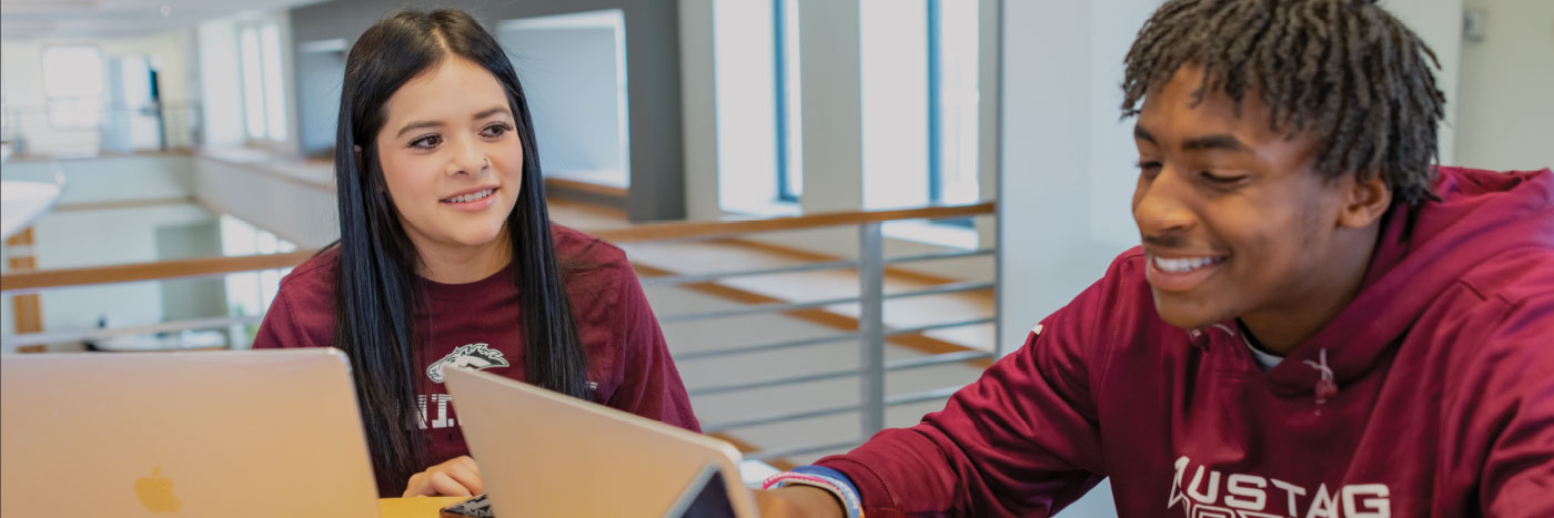 two students laughing together while studying