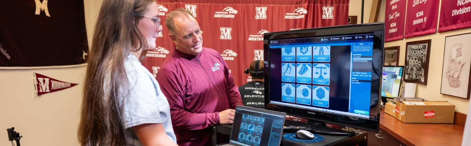 student and professor at a computer studying exercise.