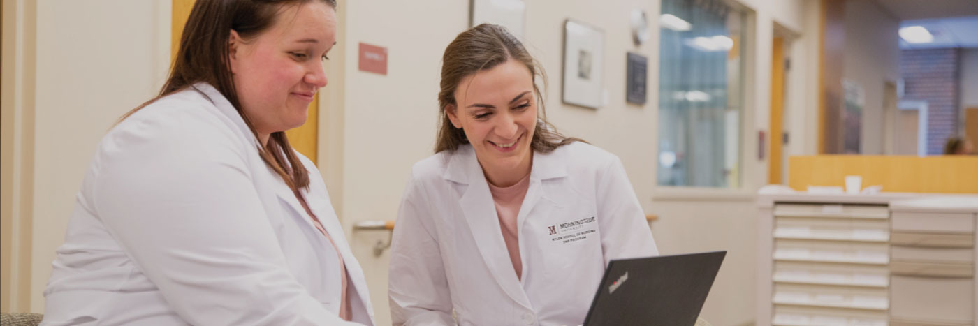 two graduate nursing students on computer