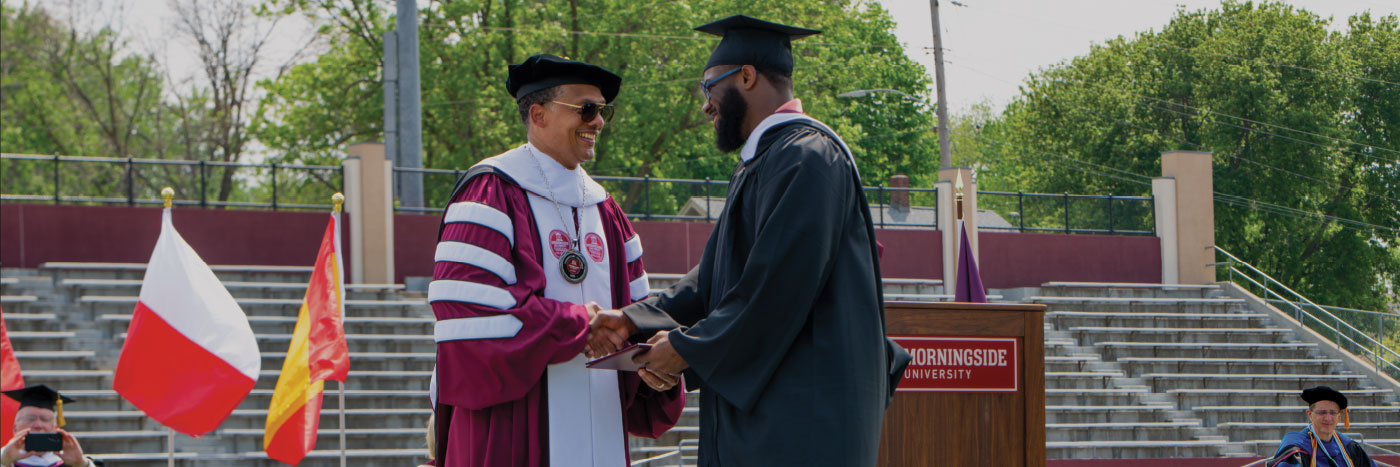 graduate shaking president mosley's hand while receiving diploma