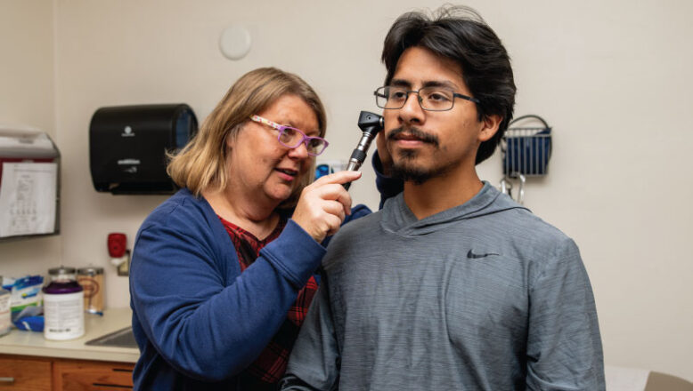 campus nurse checking students ears