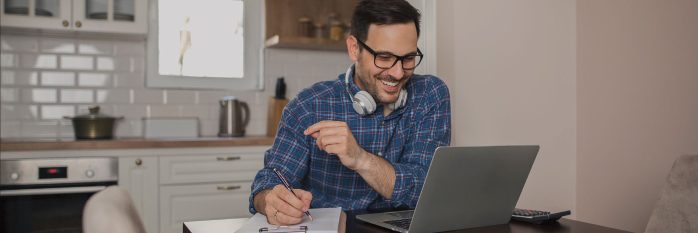 man sitting at computer in kitchen