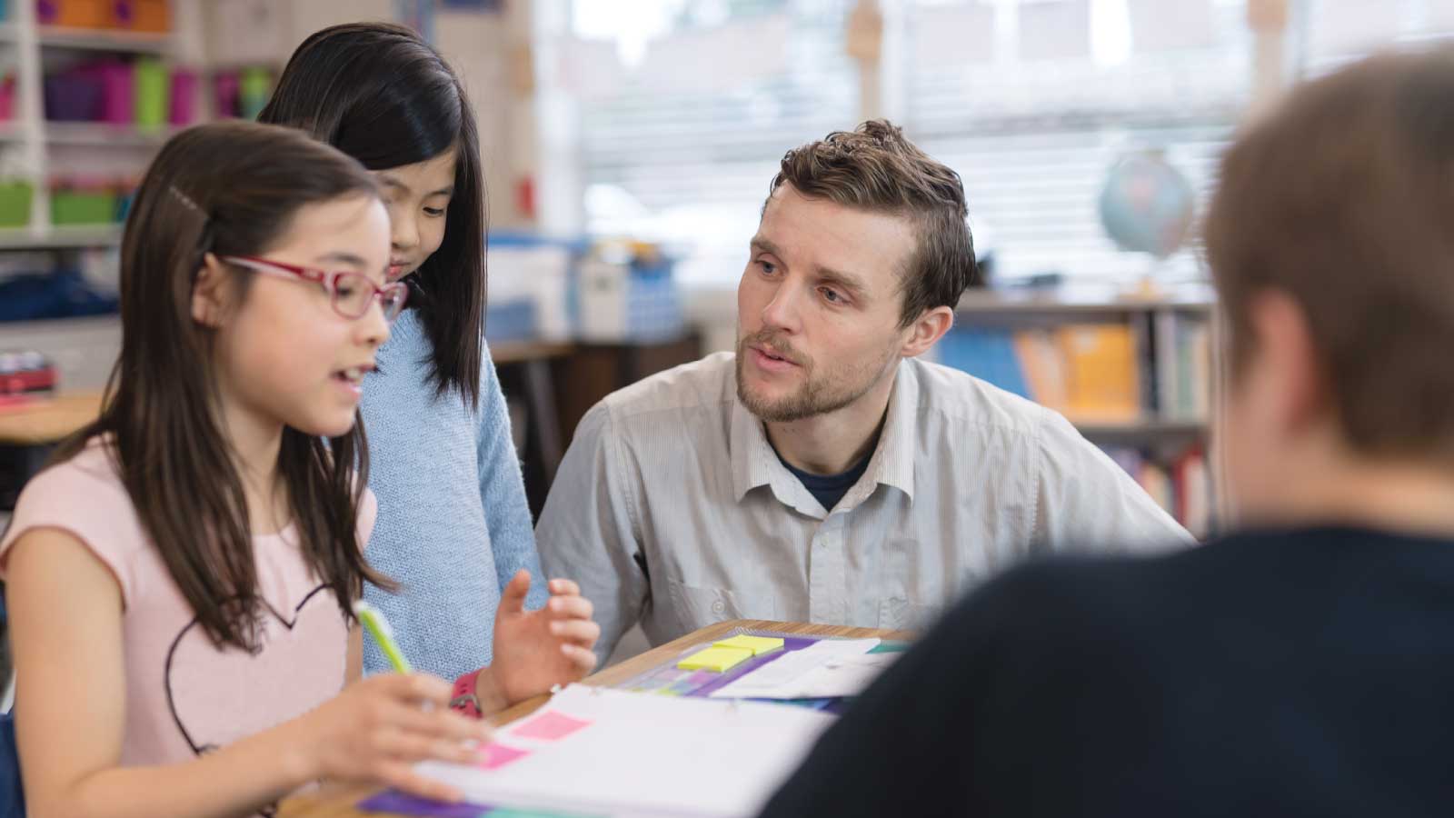 man teaching elementary students