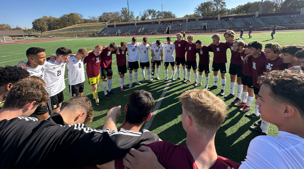 The men's soccer team huddles before a match.