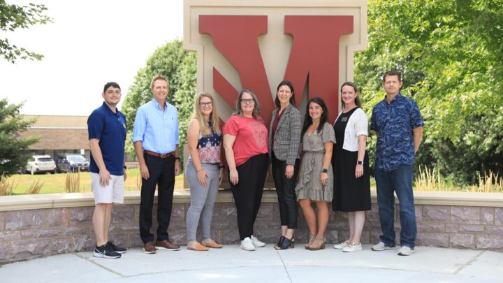 New Faculty standing by entry way M