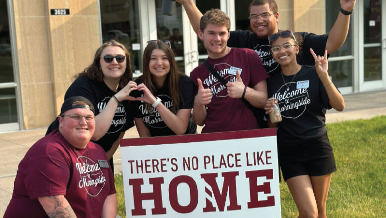 students in front of sign that says there's no place like home