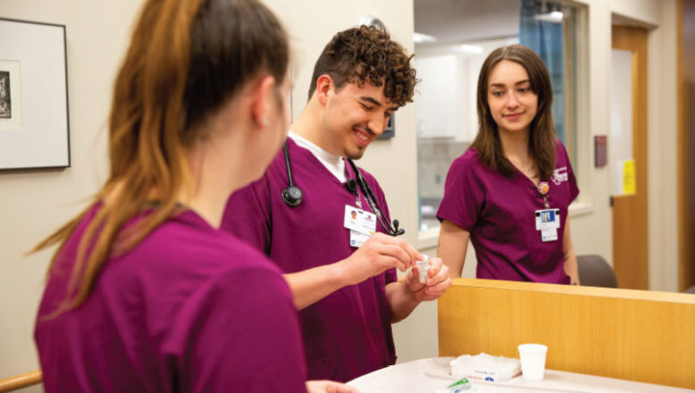 3 nursing students talking while working at a medical counter