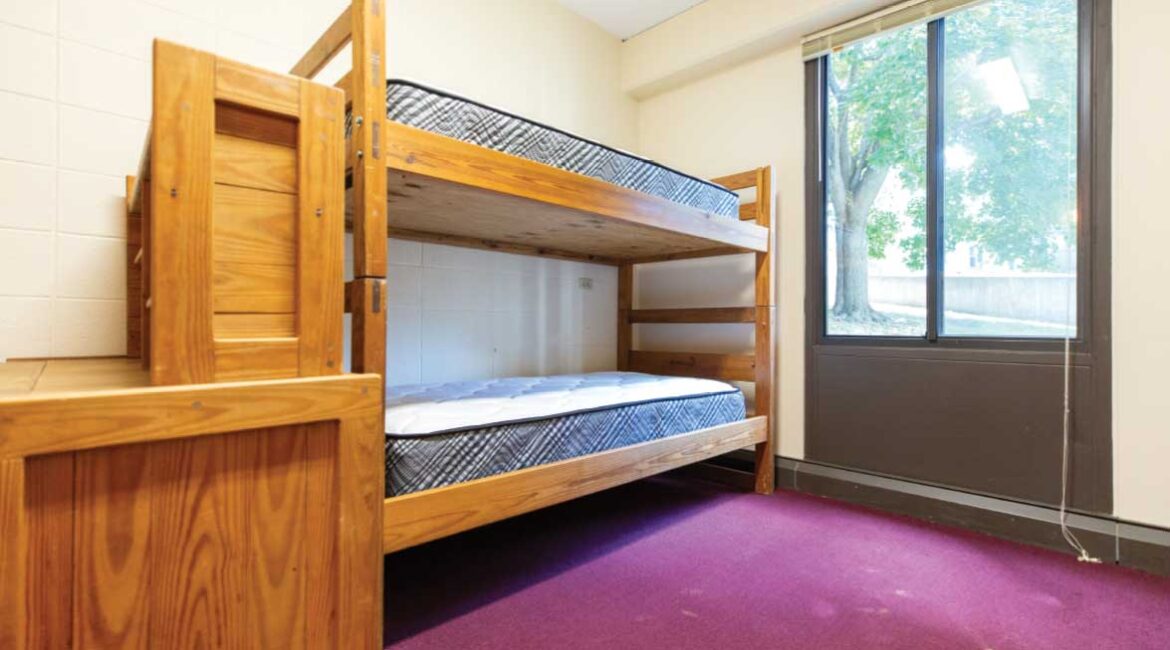 Close up of bunk beds and a desk in a room in the Plex. 