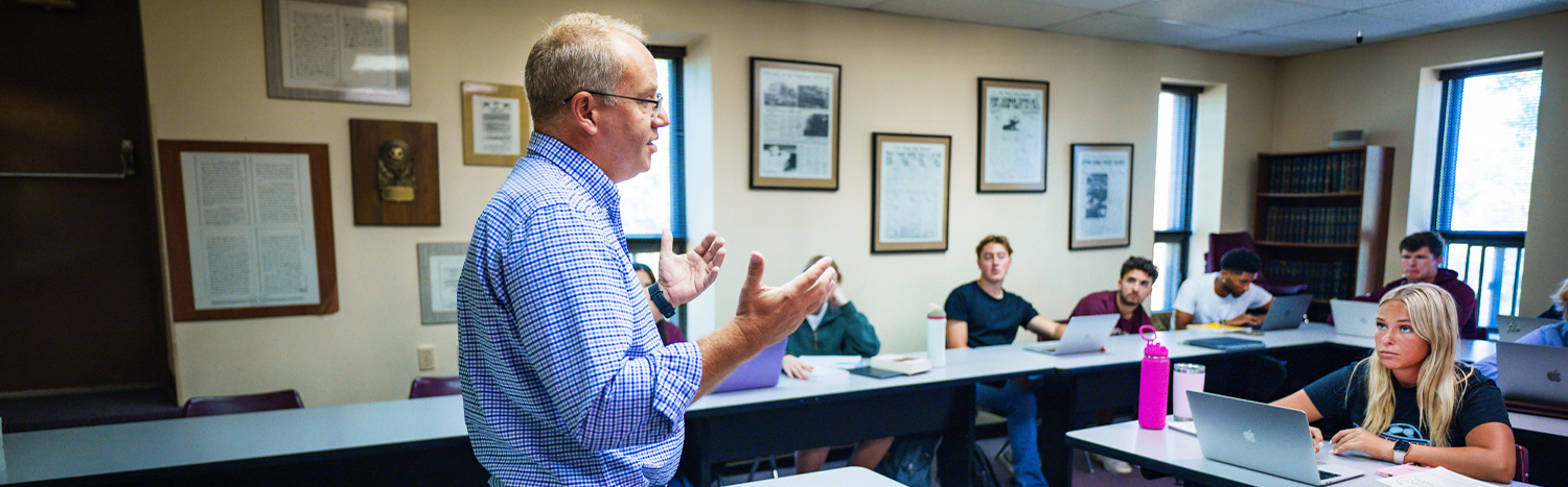 Professor lecturing to students in a classrom