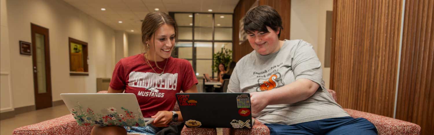 two students talking in Lewis Hall lobby