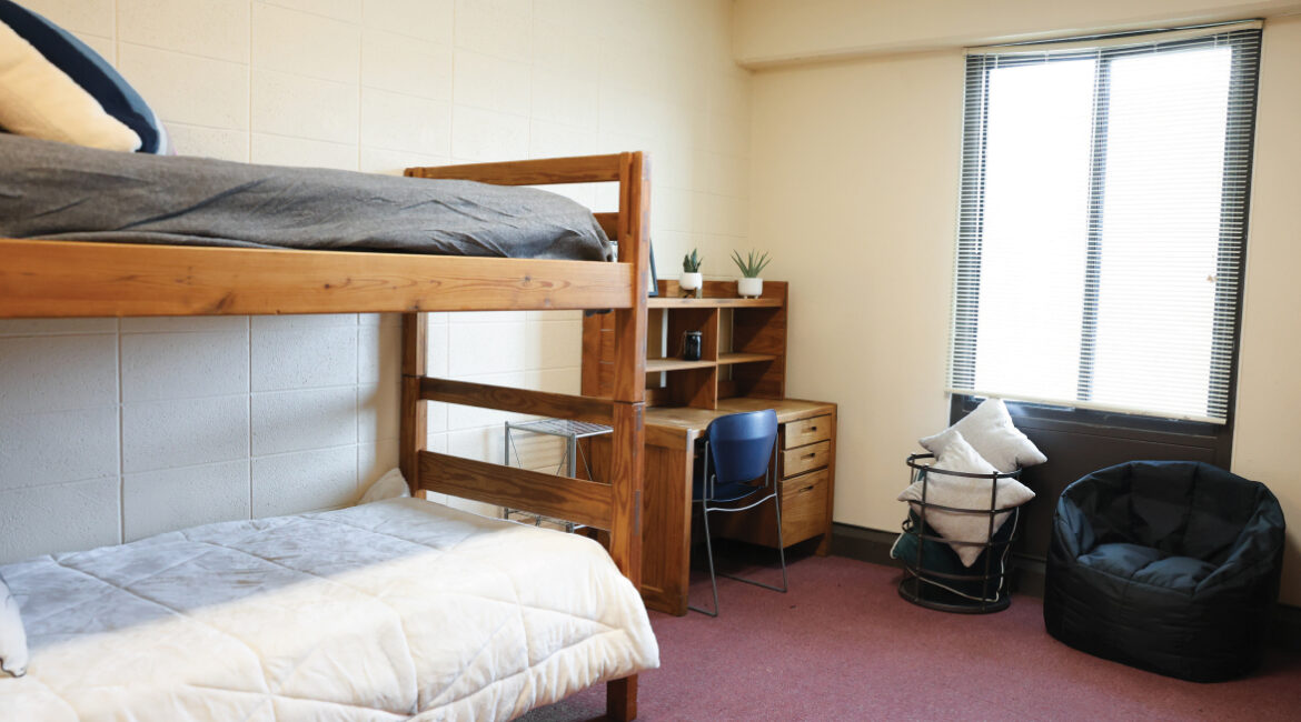 Close up of bunk beds and a desk in a room in the Plex. 