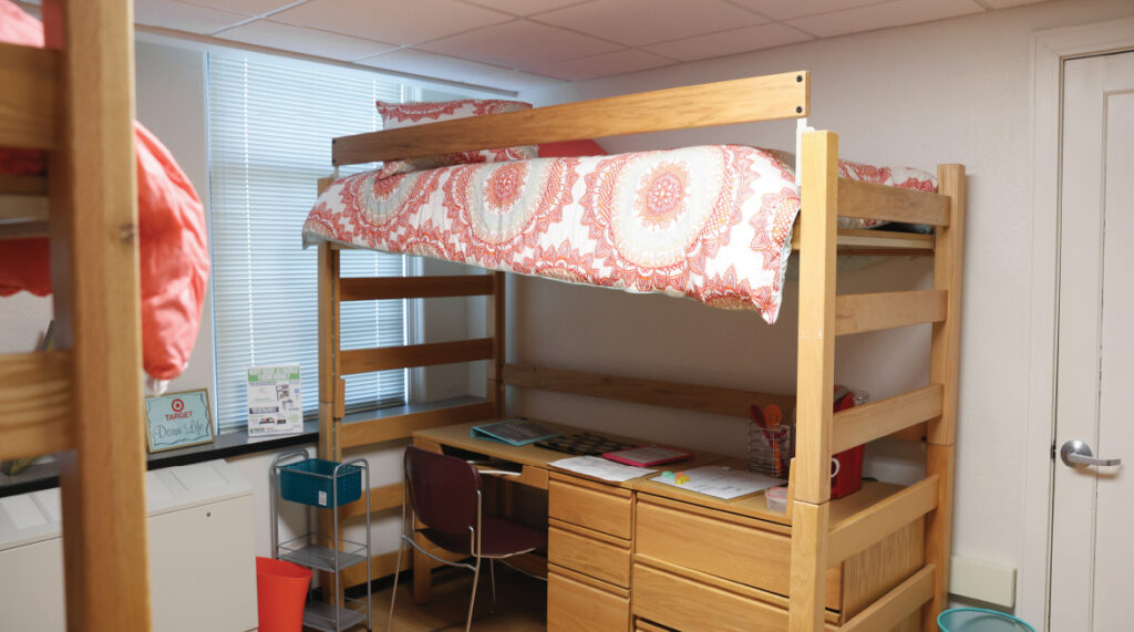 view of a room in Dimmitt Hall. Lofted bed with a desk, dresser, and chair underneath.