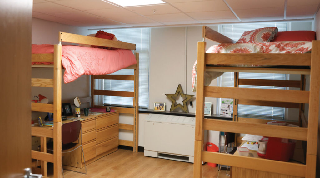 A room in Dimmitt Hall. Two lofted beds, each with a desk, dresser, and chair under them.