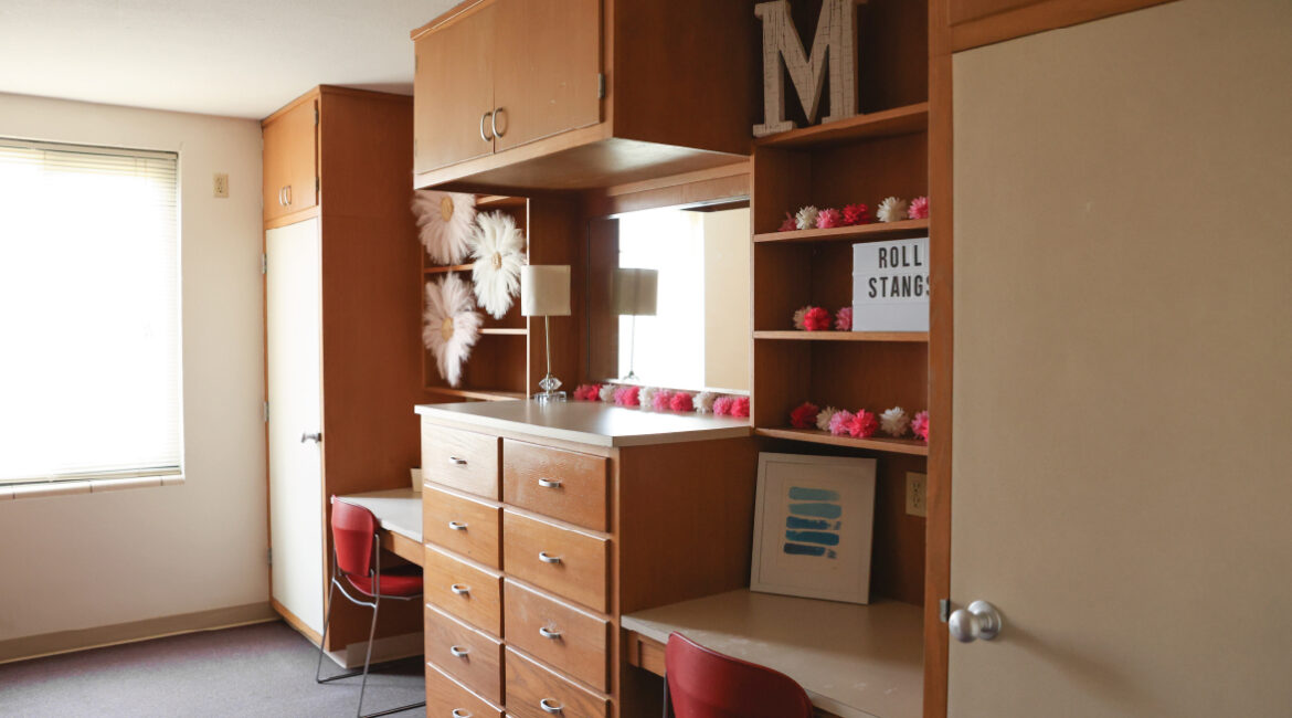 Close up of the build in desks, shelving, and dressers in a room in Roadman hall.