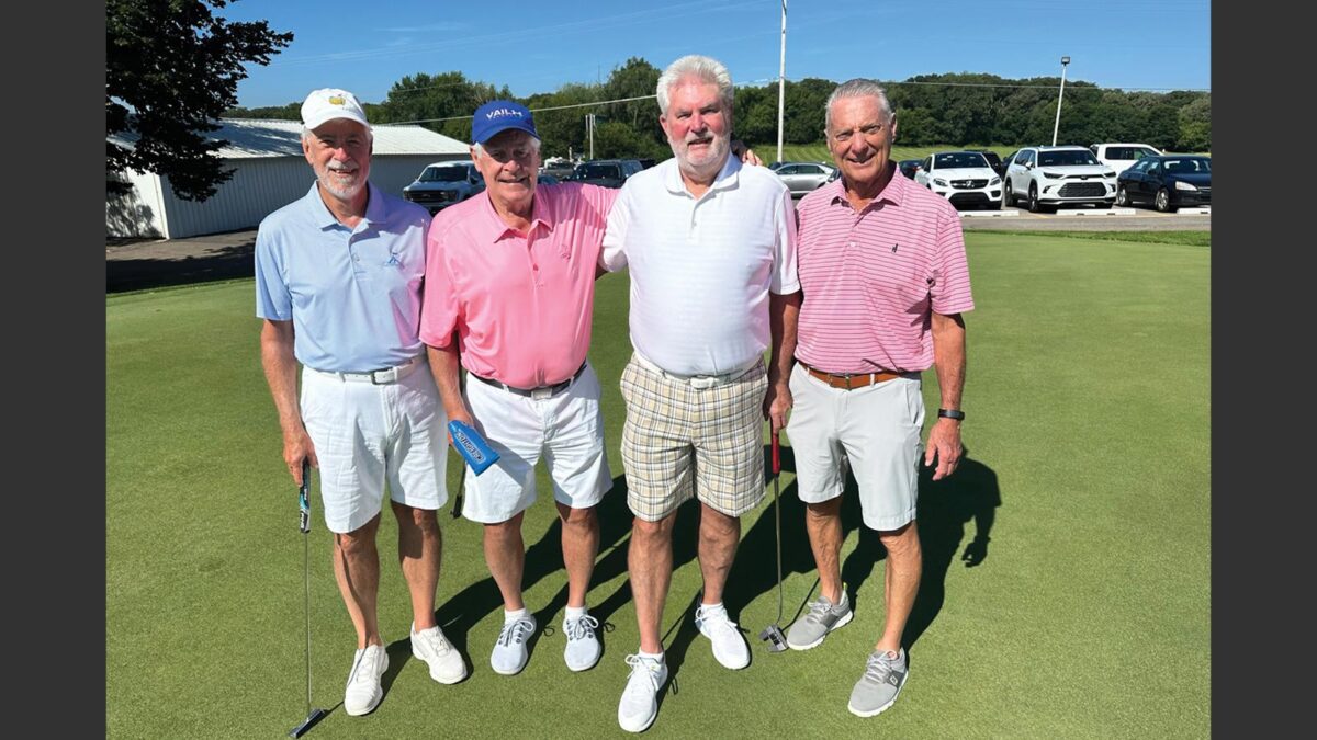 four golfers pose for photo