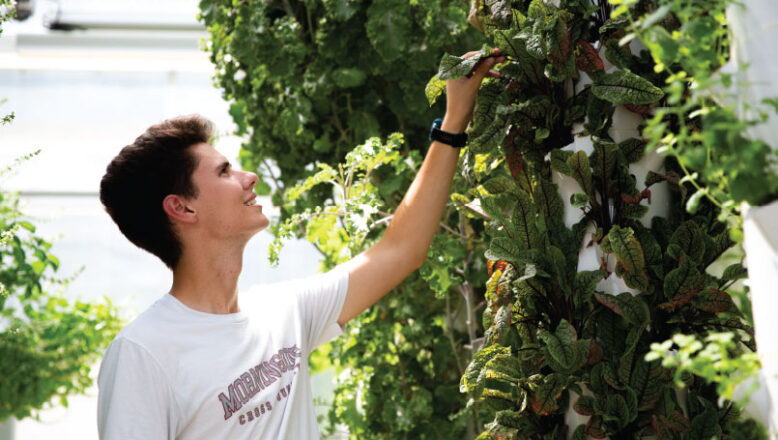 student in campus greenhouse