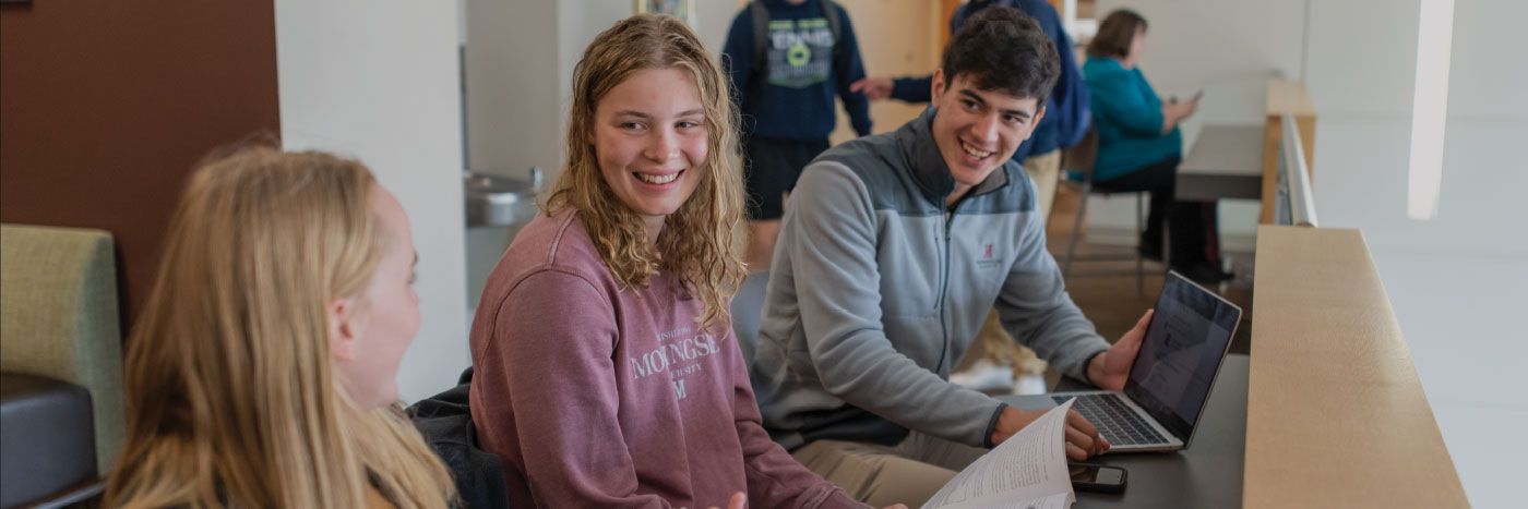 three students chatting at a table